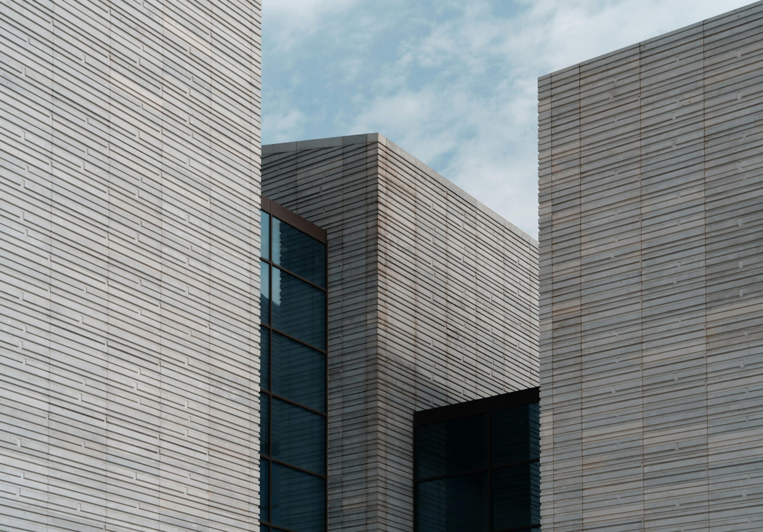 Contemporary minimalist building facade with clear sky background, architectural elegance.